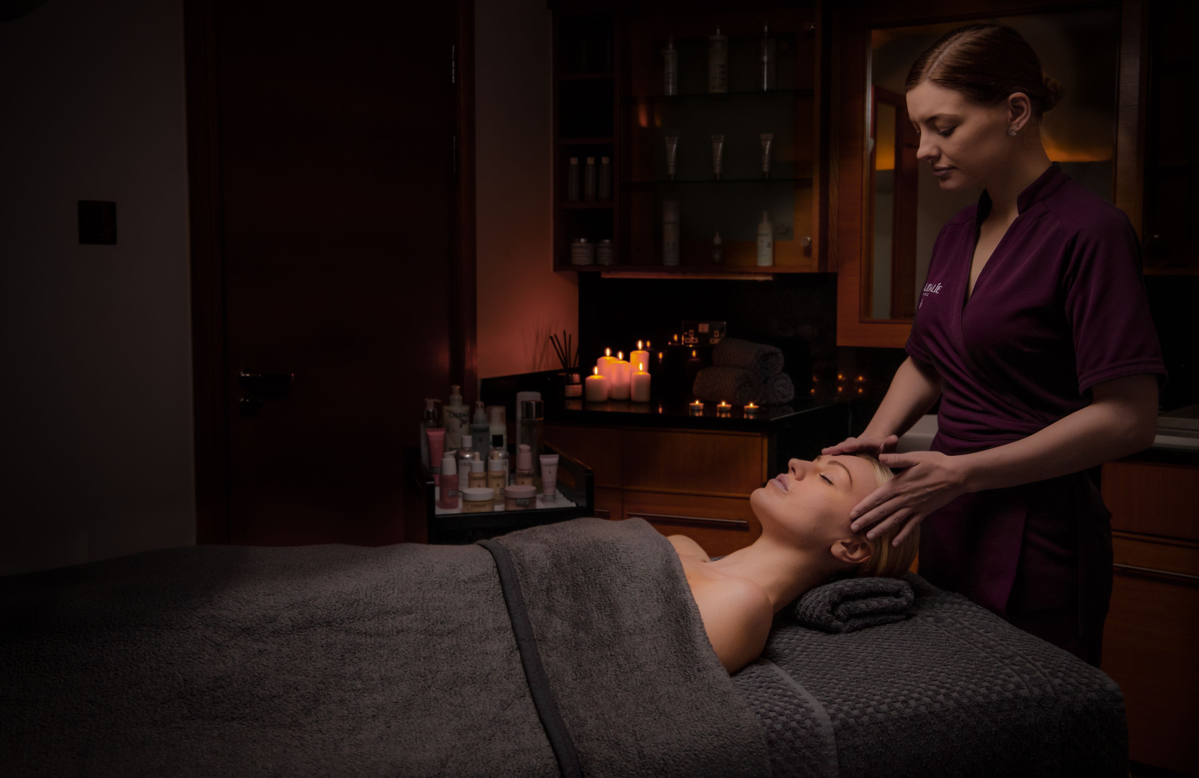 person receiving a head massage on a spa table