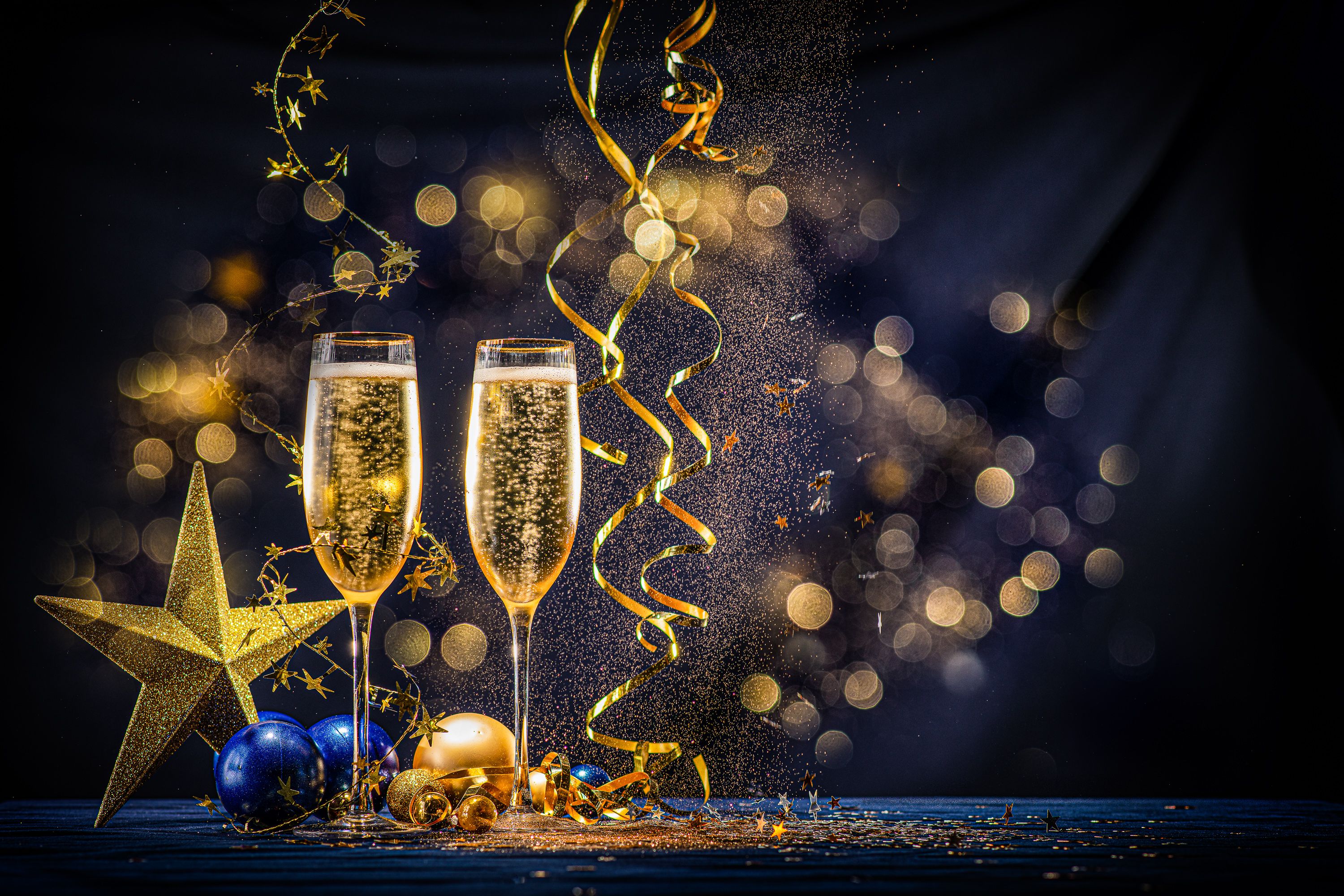 two glasses of champagne with decorations and streamers