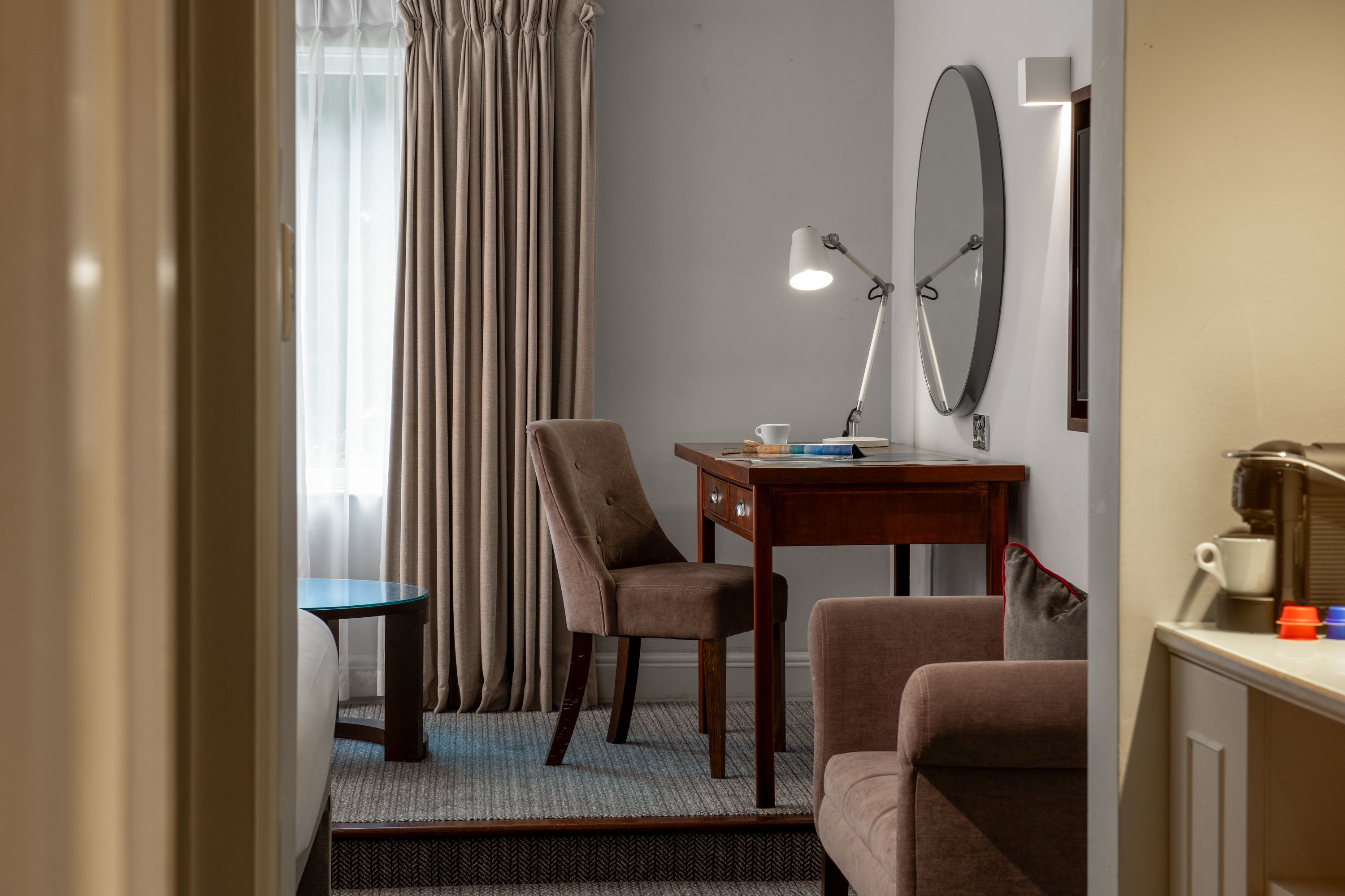 hotel room with desk, chair, and neutral accents