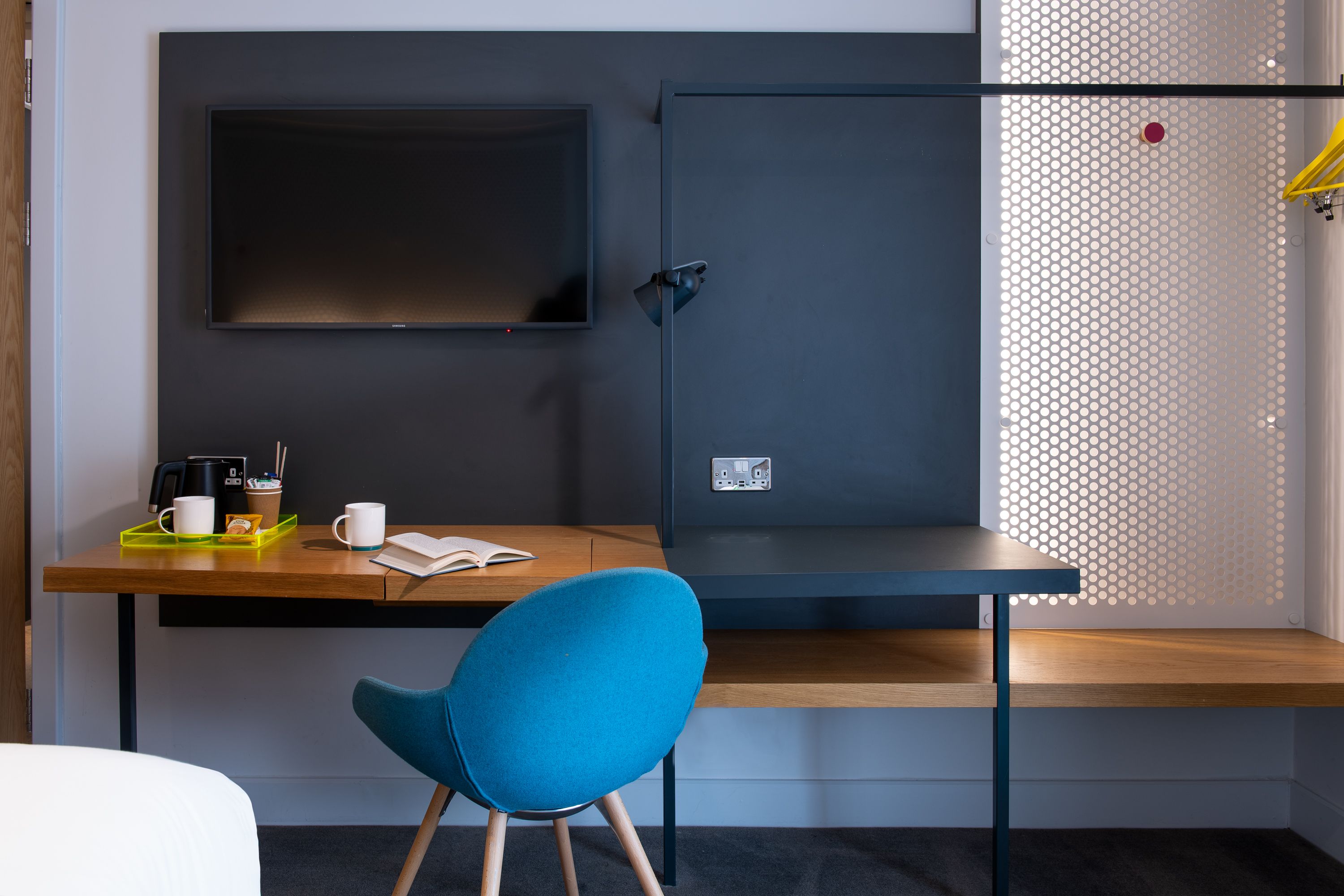 hotel room with desk, chair, and TV