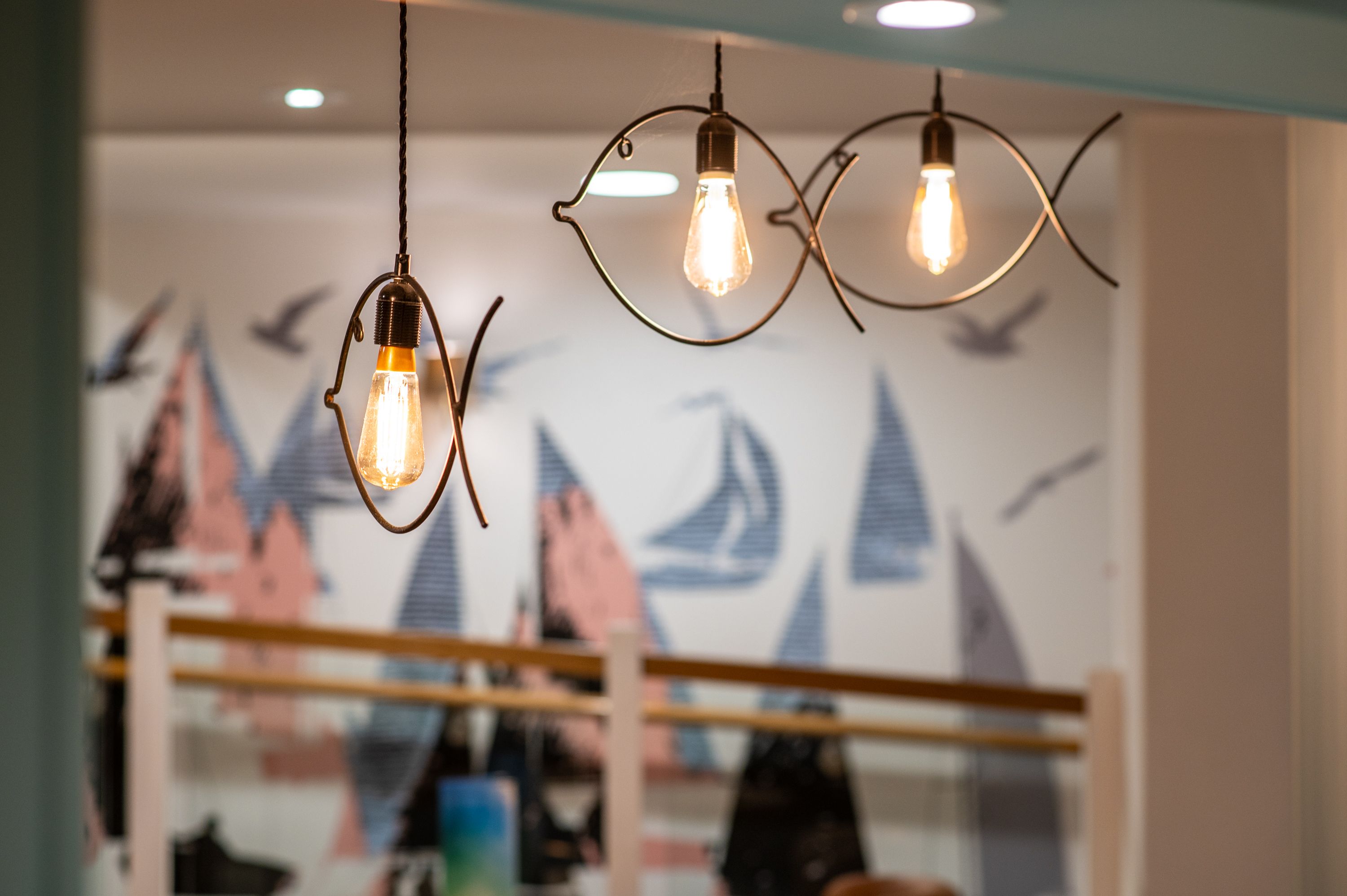 fish-shaped pendant lights with nautical wall art