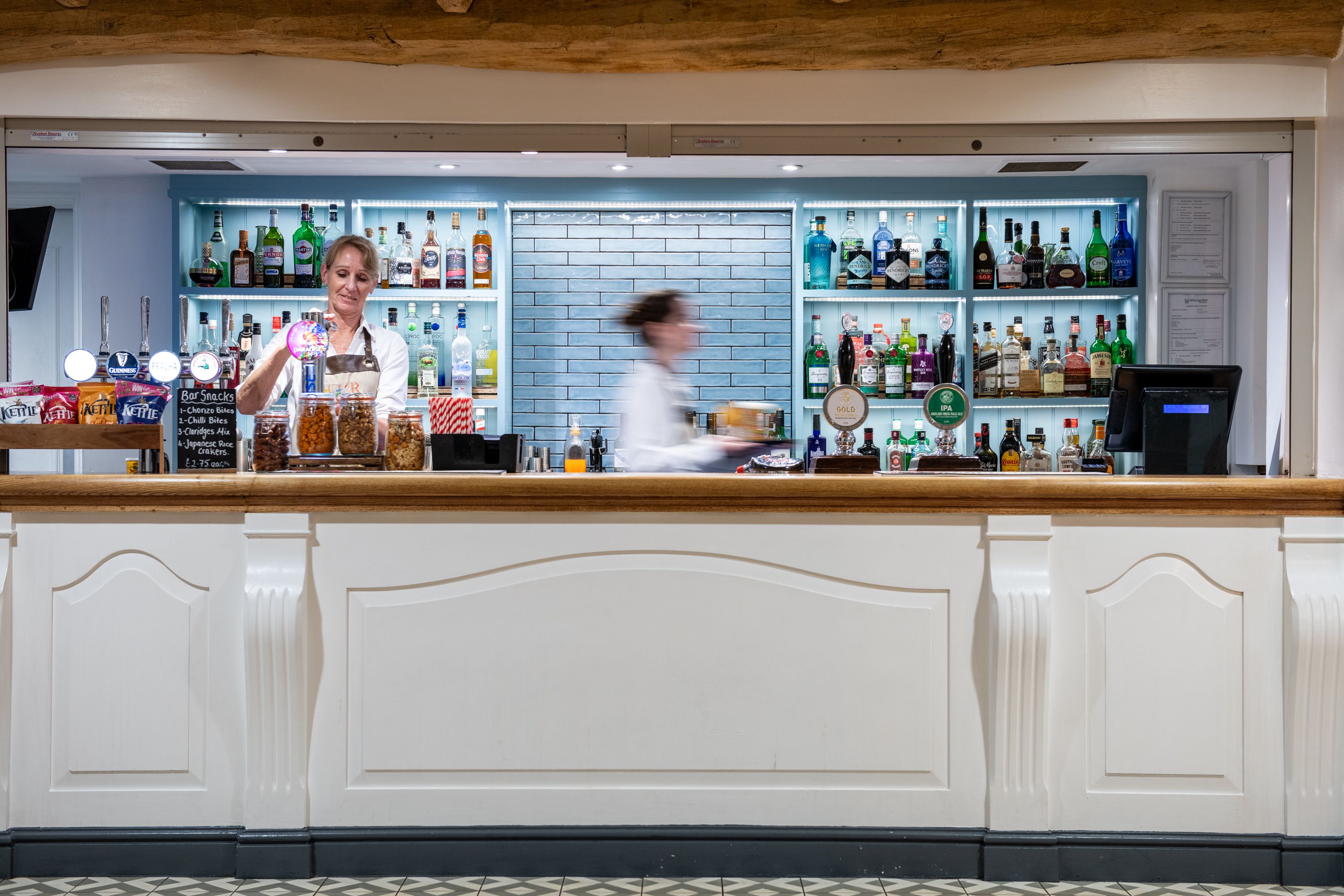 person making drinks behind a bar