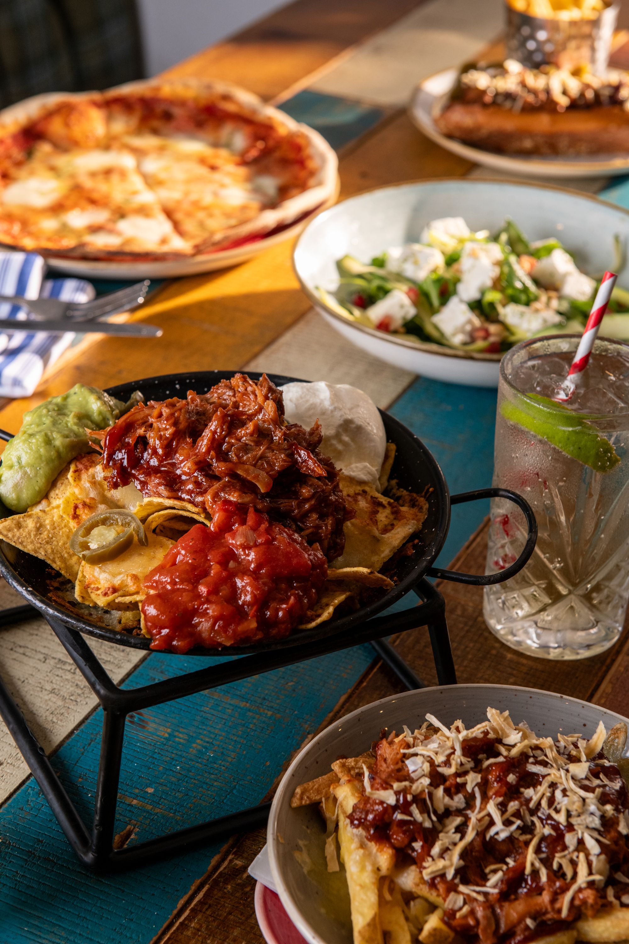 sharing platter with nachos, pizza, salad, and chips