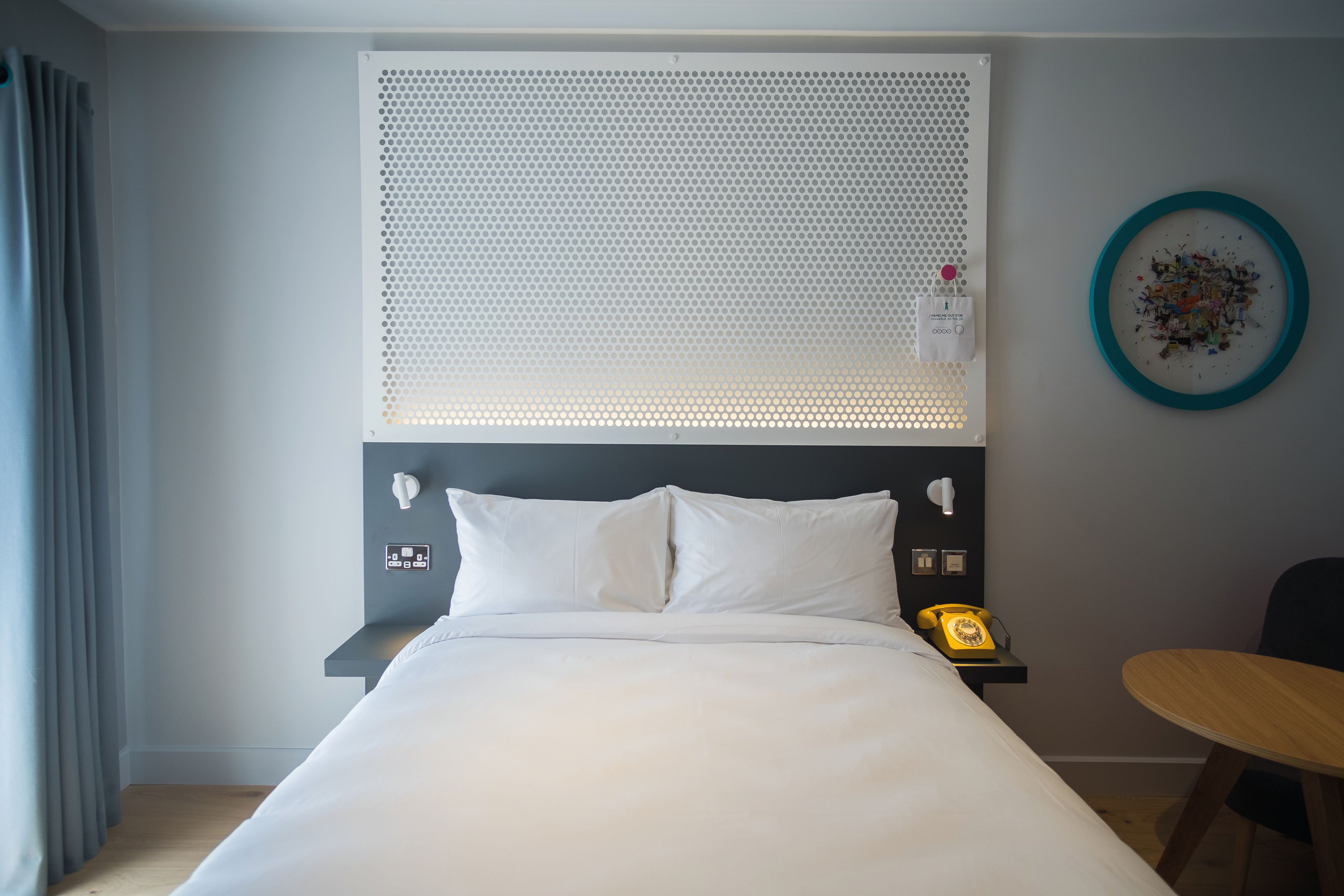 modern bedroom with white bed and perforated wall