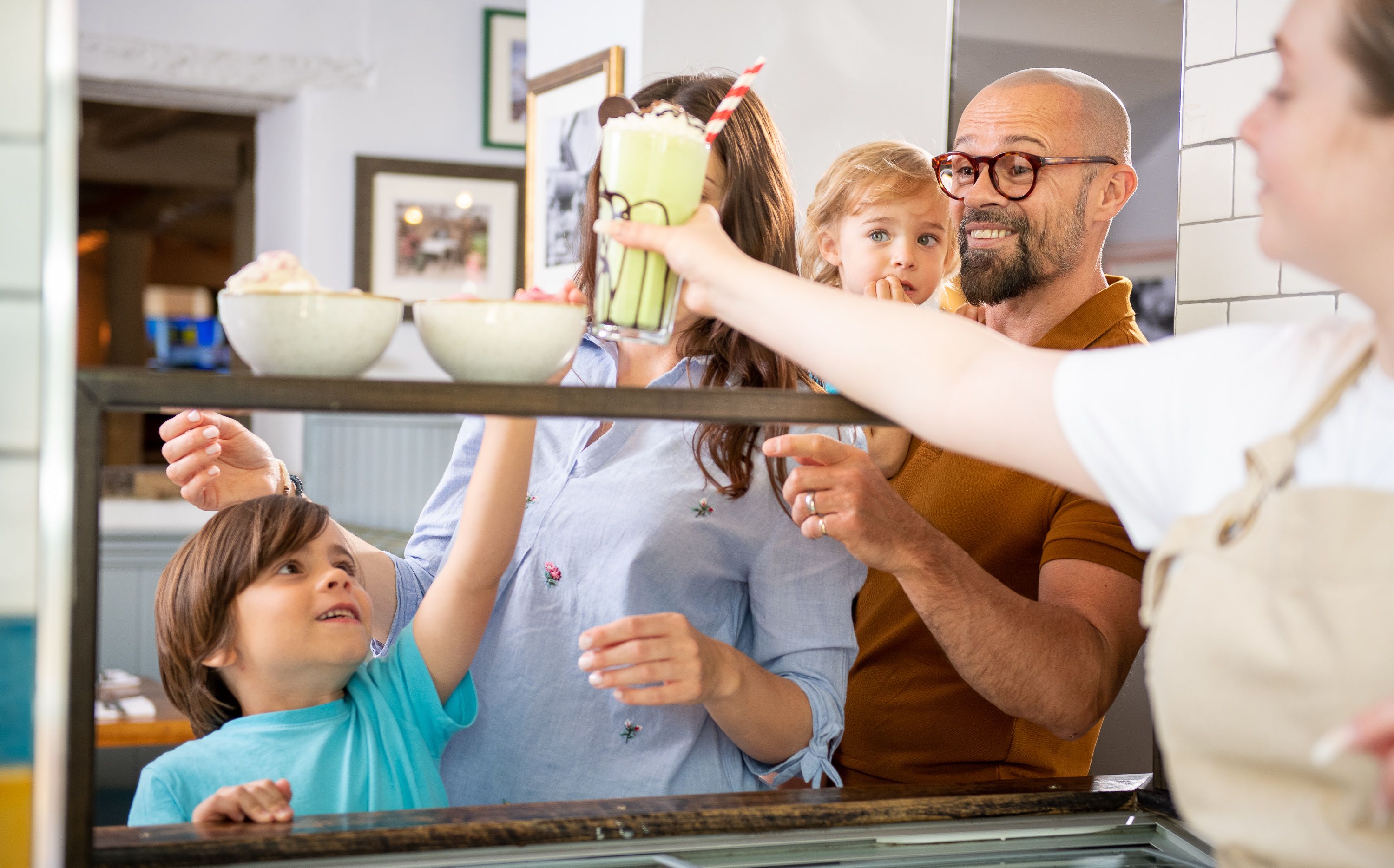 group of people looking at bowls of ice cream and a sundae