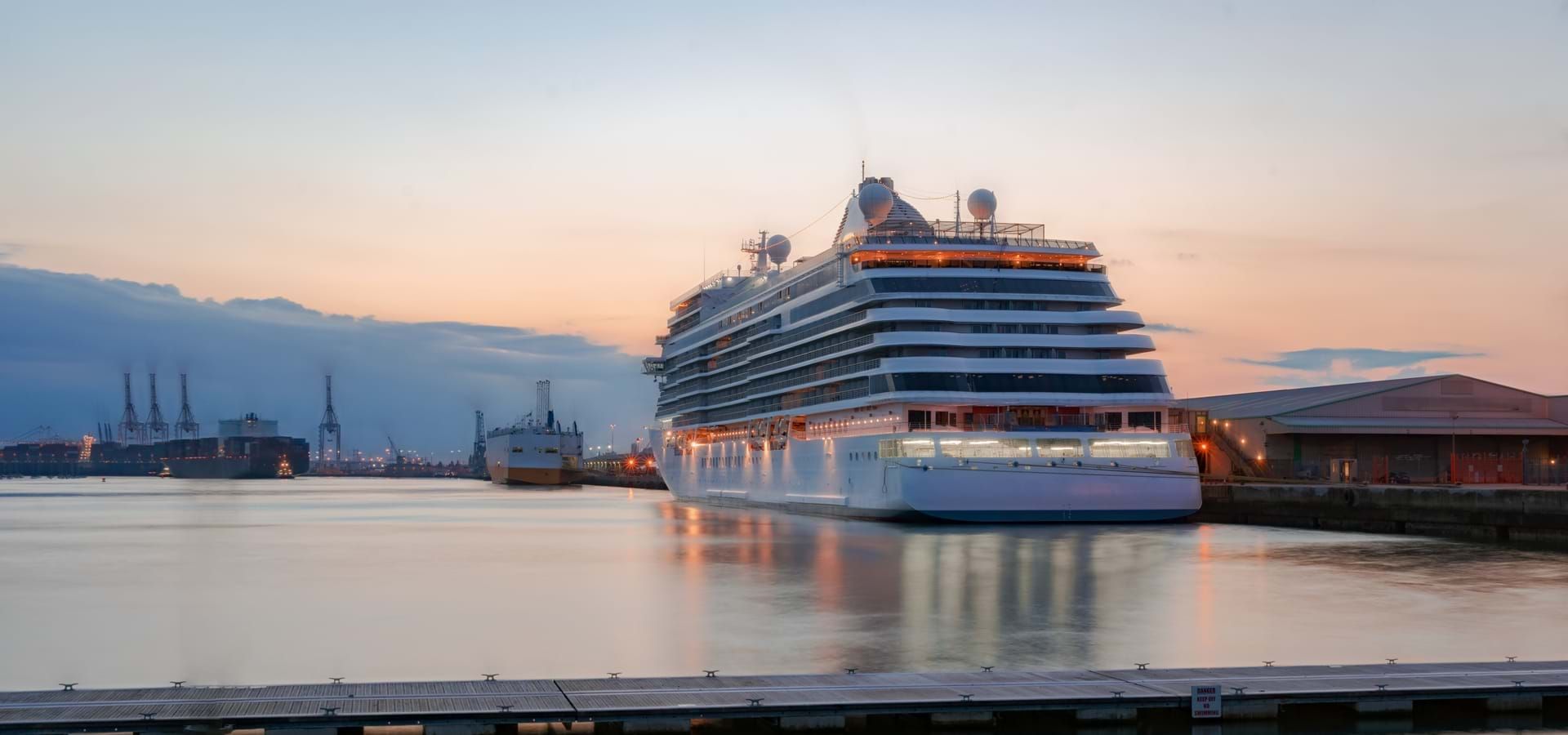 large cruise ship docked in a harbor at sunset