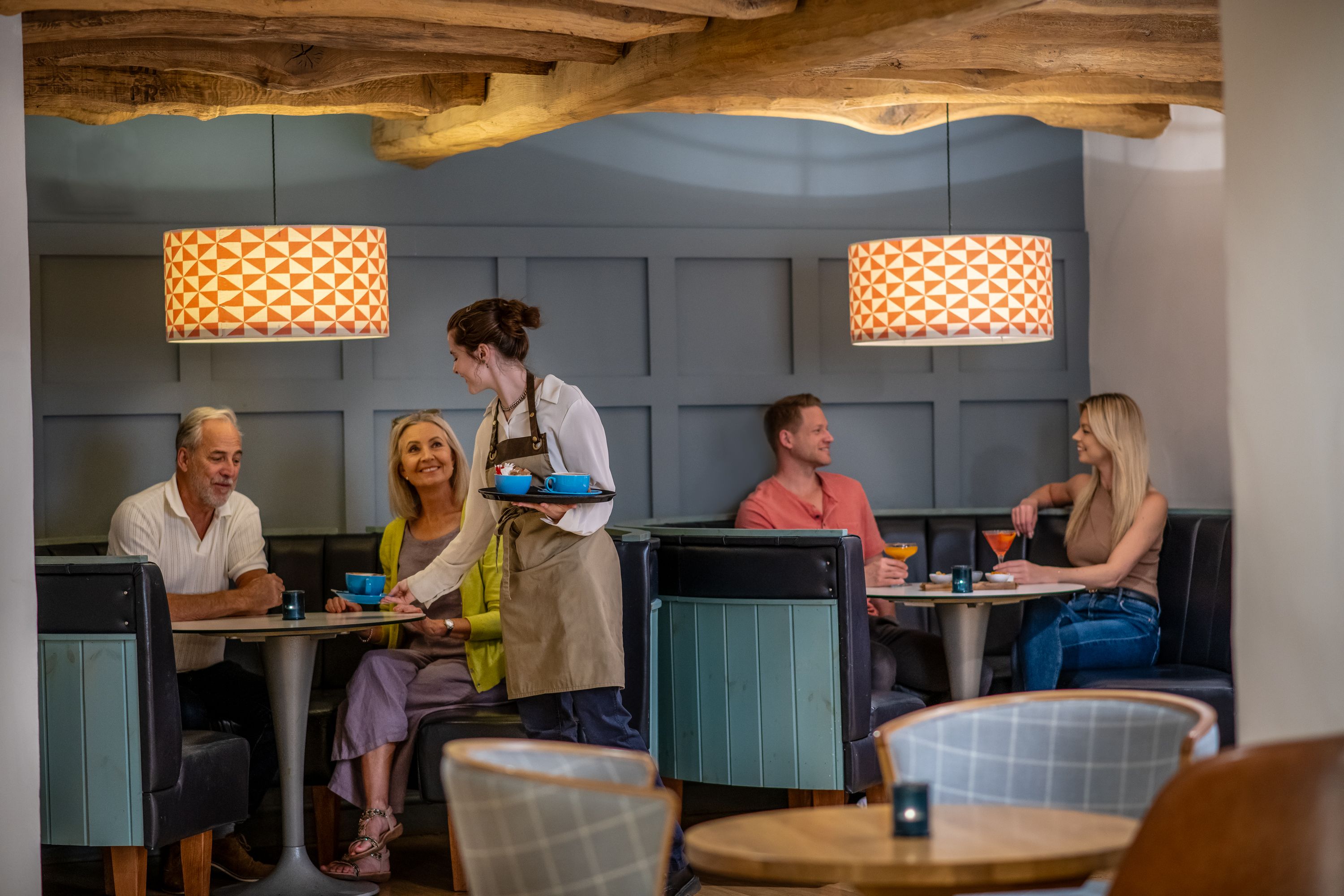 group of people sitting at tables in a restaurant