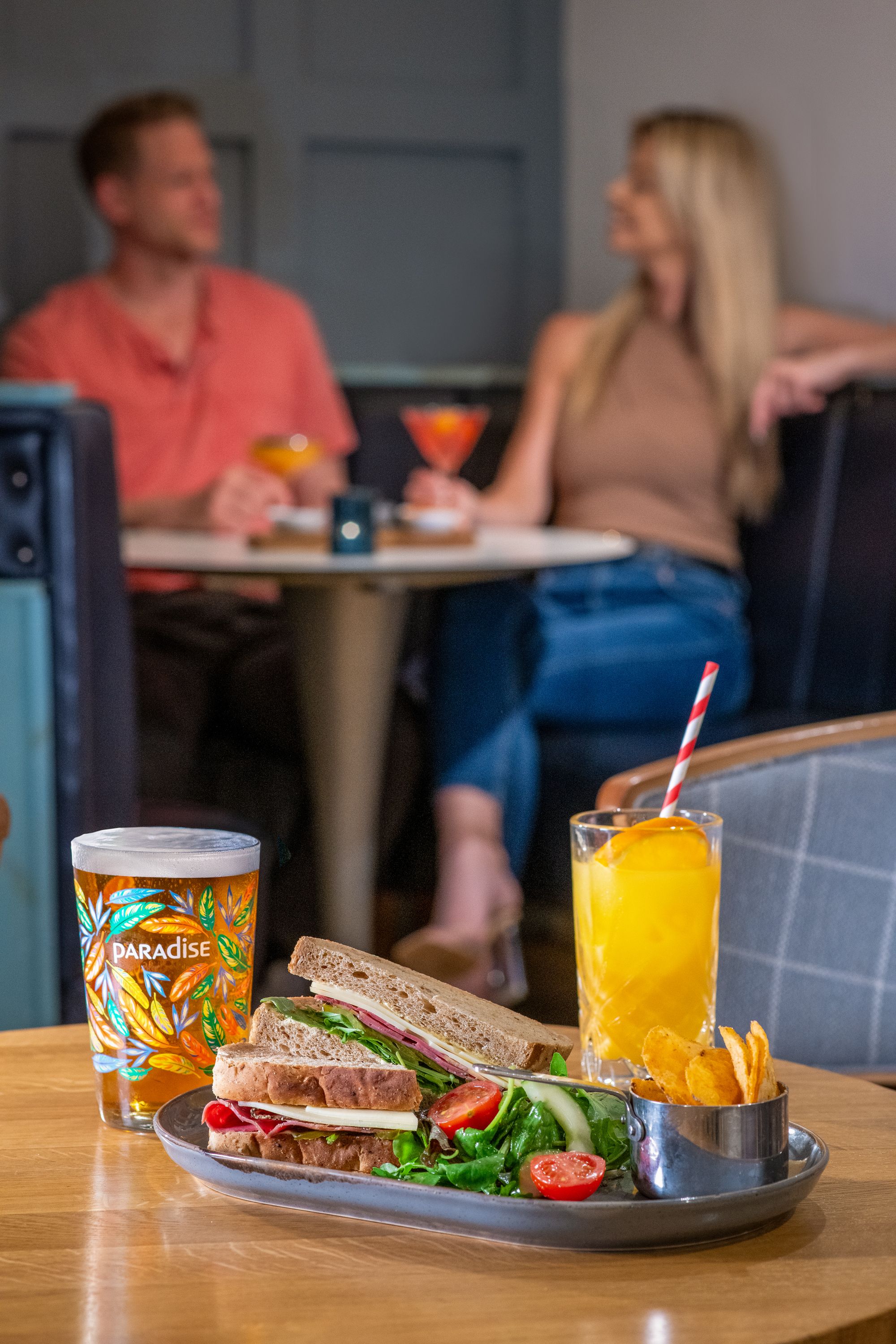 sandwich, salad, and crisps on a platter with a pint of beer