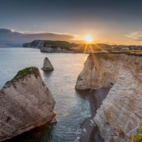 sun setting over a coastal landscape